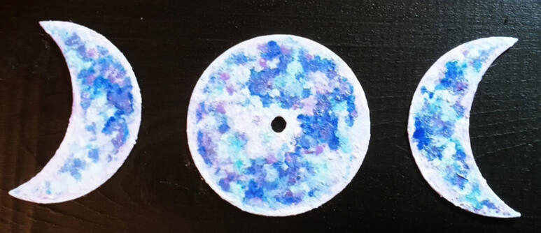 Metal cutouts in the shape of the full moon and crescent moons